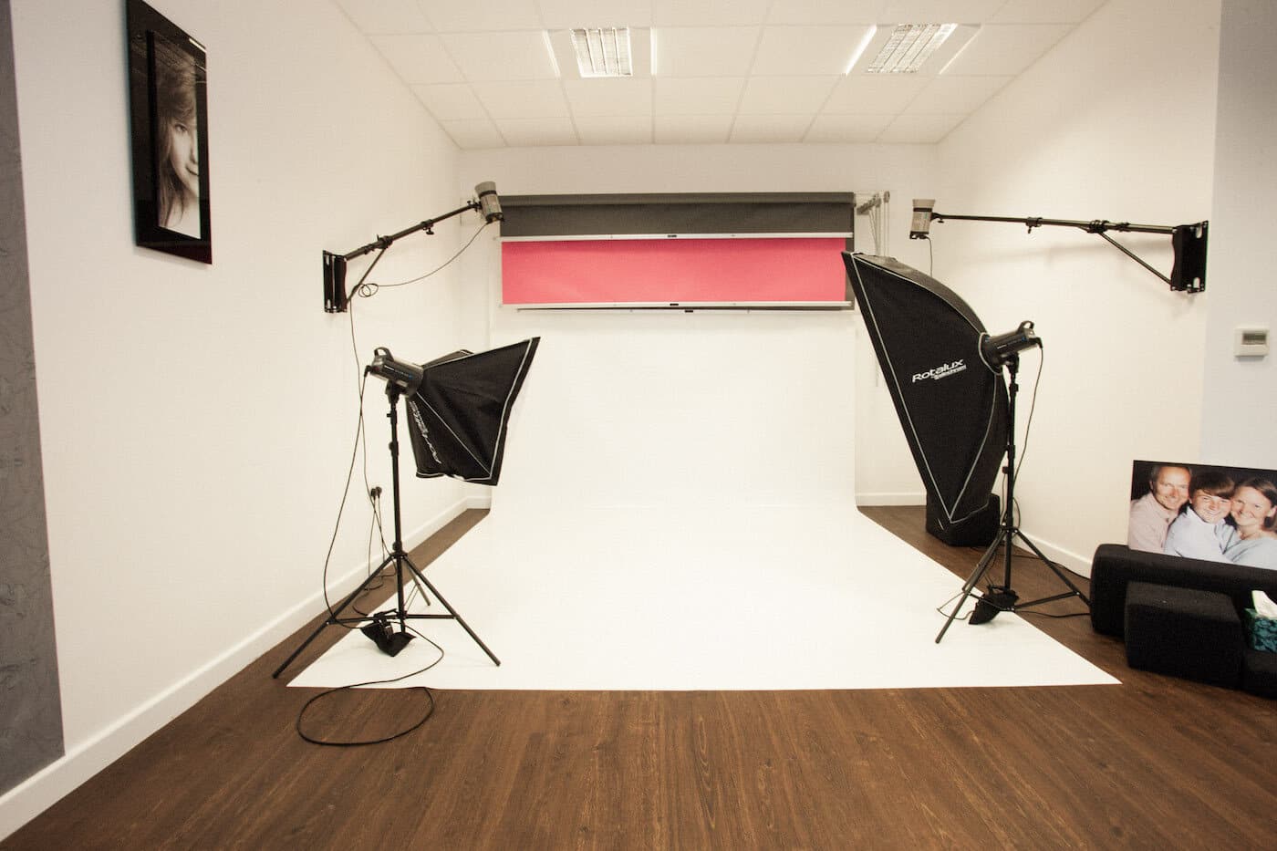 Studio set: twin softbox strobes on stands either side of a seamless white sweep, boom arms overhead